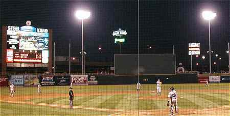 Nighttime photo of field, scoreboard and signs